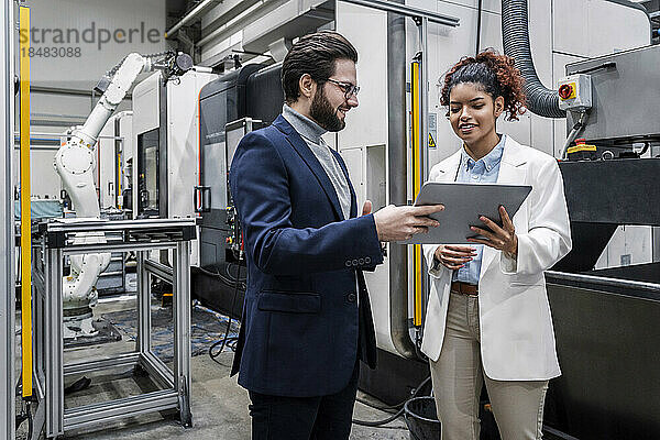 Geschäftsmann und Kollege diskutieren über Tablet-PC in der Fabrik
