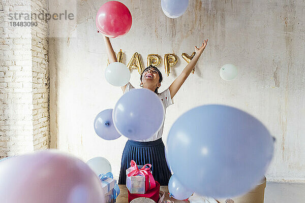 Glückliche Frau  die mit Luftballons genießt