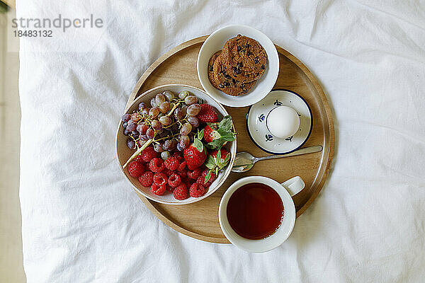 Breakfast on wooden tray in bed at home