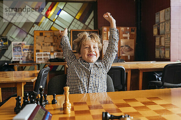Glücklicher Junge  der in der Schachschule spielt