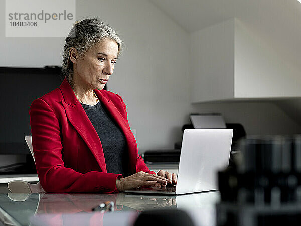 Ältere Geschäftsfrau arbeitet im Büro am Laptop