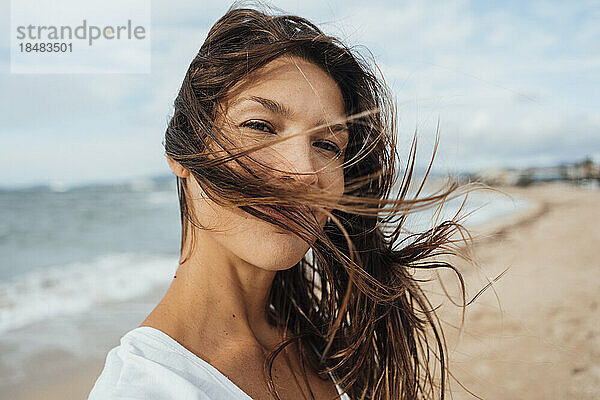 Brünette Frau mit langen Haaren verbringt ihre Freizeit am Strand