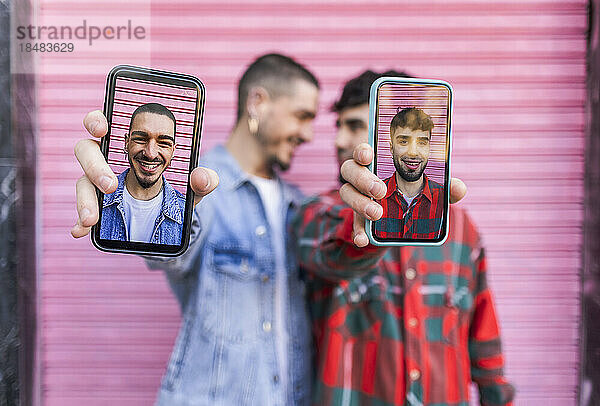 Glückliche schwule Menschen  die durch den Bildschirm eines Smartphones gesehen werden
