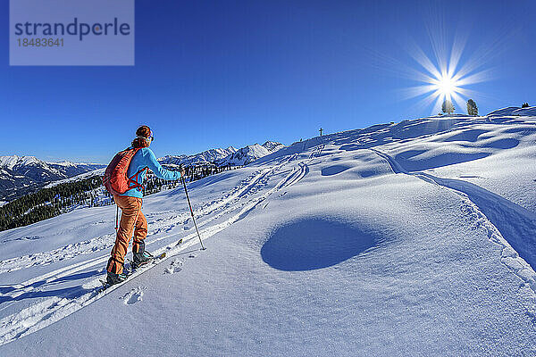 Austria  Tyrol  Female skier ascending snowcapped slope of Schonbichl