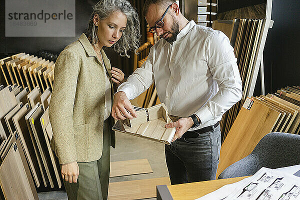 Zwei Kollegen arbeiten gemeinsam im Architekturbüro an einem Holzmodell