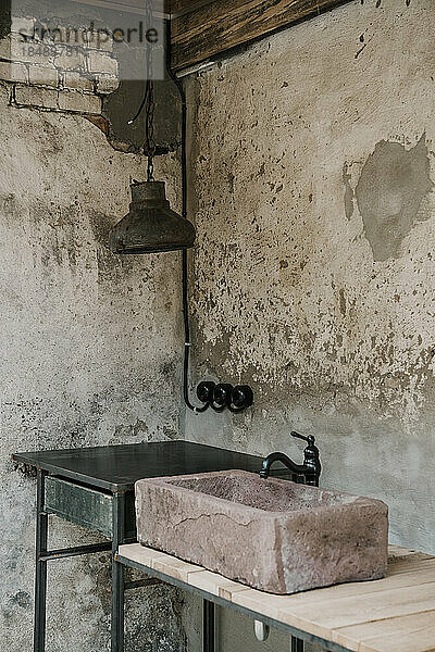 Wasserhahn und Waschbecken in der Nähe der alten Wand im Badezimmer