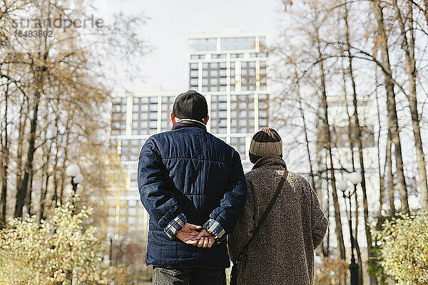 Ältere Männer und Frauen spazieren im Herbstpark
