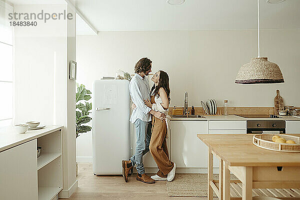 Glückliches Paar  das zu Hause zusammen in der Küche steht