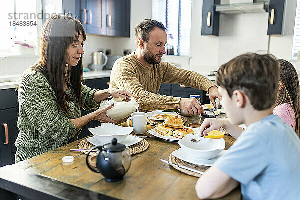 Familie frühstückt gemeinsam in der Küche