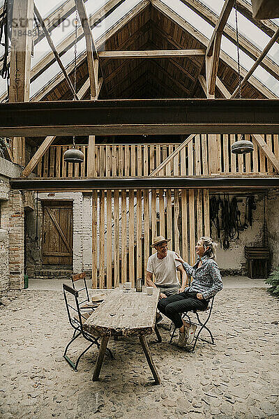 Mann und Frau sitzen zusammen am Esstisch im Bauernhaus