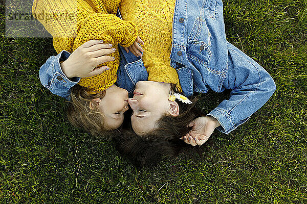 Mädchen liegt mit Mutter im Park auf Gras