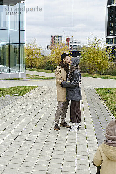 Mann und Frau küssen sich am Fußweg