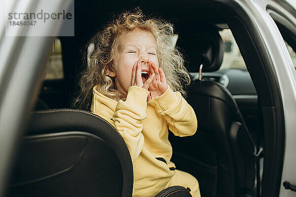 Verspieltes Mädchen schreit im Auto