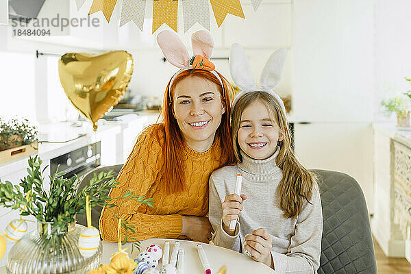 Glückliche Mutter mit Tochter  die zu Hause Ostern feiert