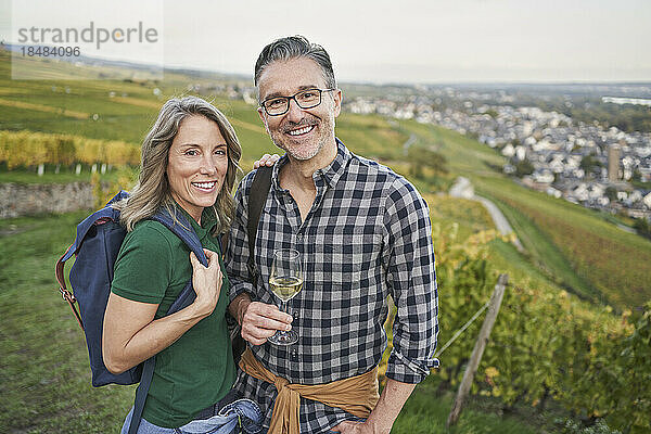 Reife Frau mit Mann hält Weinglas auf Hügel
