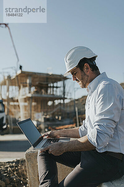 Architekt arbeitet am Laptop auf der Baustelle