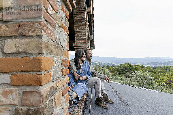 Glückliche reife Frau und Mann sitzen auf dem Dach