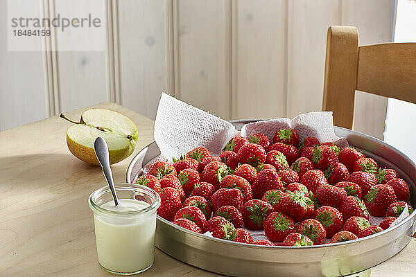 Frische reife Erdbeeren und ein Glas Joghurt