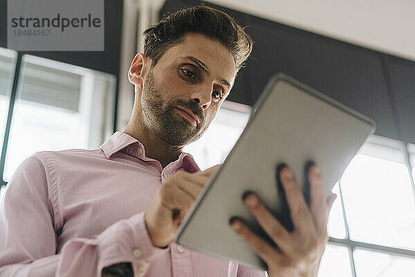 Reifer Geschäftsmann nutzt Tablet-PC im Büro
