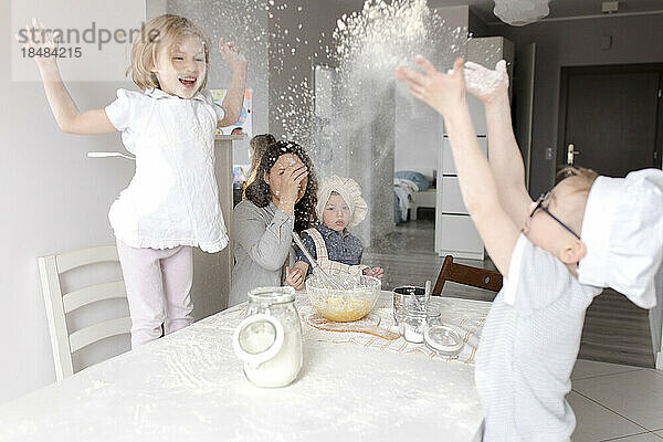Verspielte Kinder genießen Mehl in der Küche