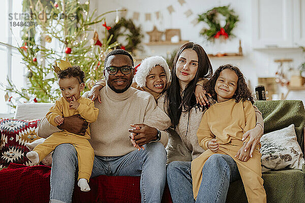 Glückliche Familie  die zu Weihnachten zusammen auf dem Sofa sitzt