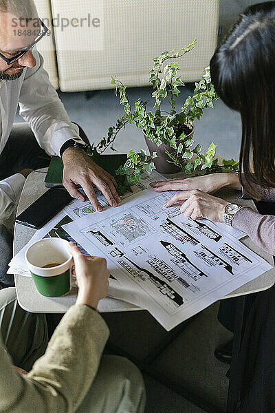 Geschäftsmann und Geschäftsfrau treffen sich mit dem Kunden im Architekturbüro und besprechen den Bauplan