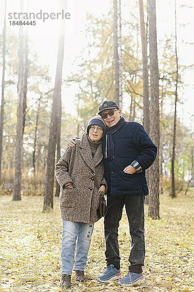 Älterer Mann mit Arm um Frau  die im Park steht