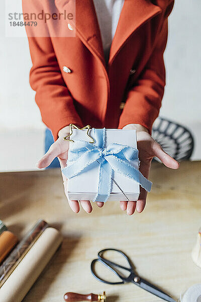 Hände einer Frau  die eine Geschenkbox hält