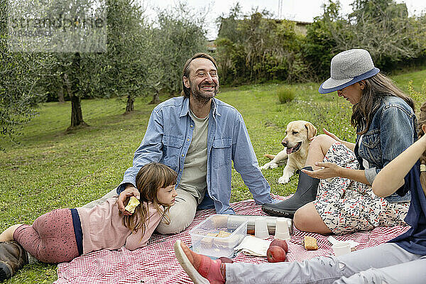 Glückliche Familie  die zusammen ein Picknick auf dem Feld macht