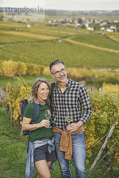 Nachdenkliches Paar mit Weingläsern  die auf einem Hügel stehen