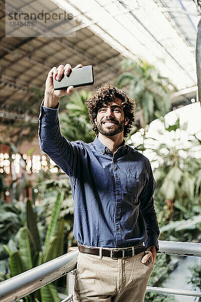 Glücklicher Geschäftsmann  der Selfie per Smartphone macht
