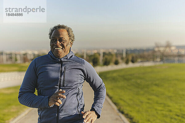Glücklicher älterer Mann beim Joggen an einem sonnigen Tag