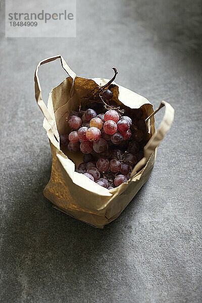 Studio shot of paper bag with fresh grapes