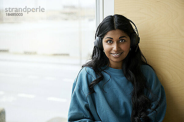 Lächelnde Frau mit Bluetooth-Kopfhörern