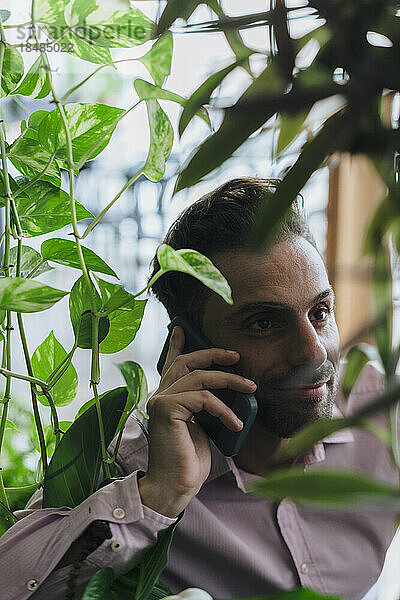 Reifer Geschäftsmann benutzt Mobiltelefon im Büro