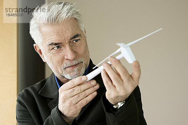 Geschäftsmann untersucht Windturbinenmodell im Büro