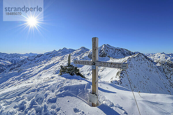 Austria  Tyrol  Sun shining over summit cross in Zillertal Alps