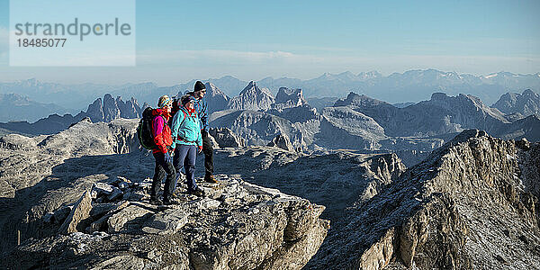 Freunde stehen an einem sonnigen Tag am Berg Piz Boe  Dolomiten  Italien