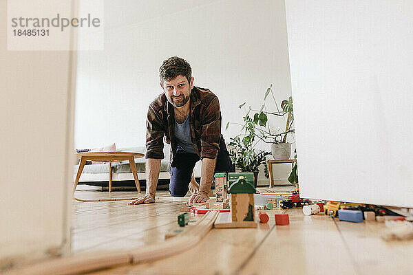 Reifer Mann mit Spielzeug im heimischen Wohnzimmer
