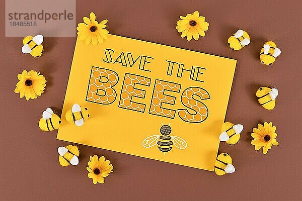 Schild Rettet die Bienen  umgeben von Filzbienen und gelben Blumen