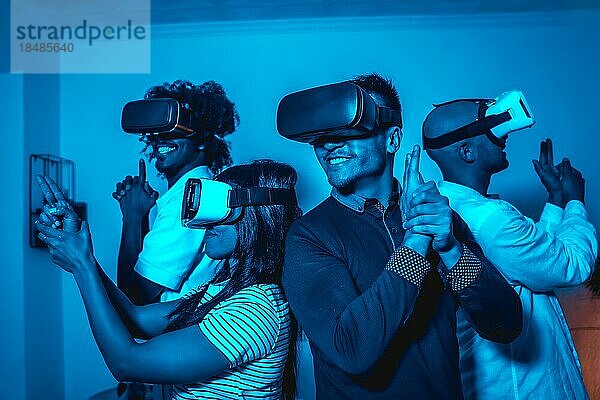 Gruppe junger Menschen mit VR Brille in einem Virtual Reality Spiel in einem blauen Licht mit Waffen  futuristisch oder Wissenschaft  Technologiekonzept