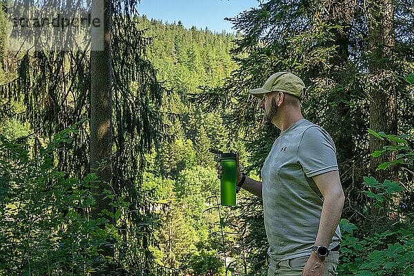 Wandersmann trinkt grüner Flasche im Wald  Bad Wildbad  Schwarzwald  Deutschland  Europa