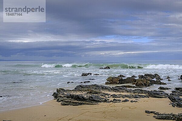 Wellen und felsige Küste  am Strand  dunkle Wolken  Jeffreys Bay bei Port Elizabeth  Garden Route  Ostkap  Südafrika