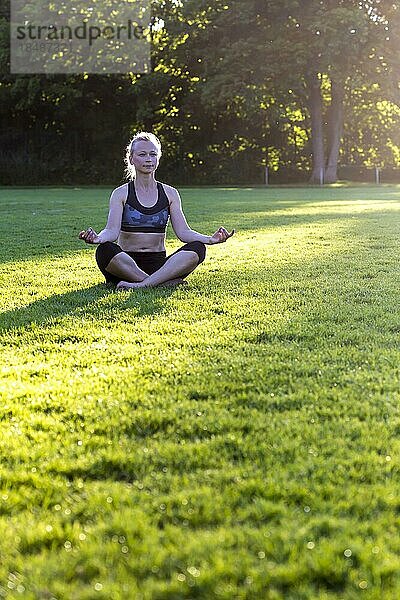 Frau (38) macht Yoga auf einer Wiese im Park  Kiel  Schleswig-Holstein  Deutschland  Europa