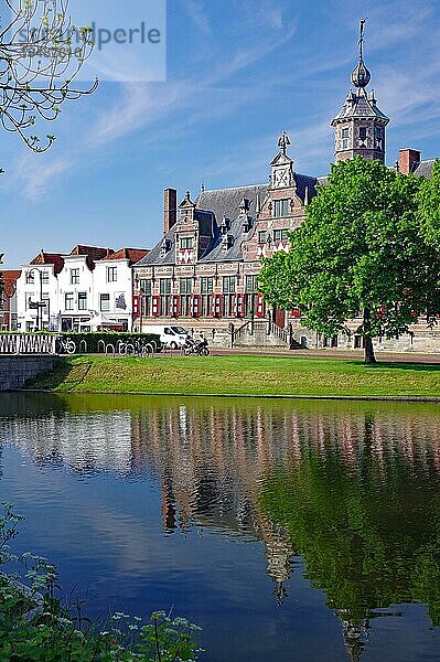 Das ehemalige Rathaus spiegelt sich im Wasser eines Kanals  Frühling  Stadhuis Middelburg  Zeeland  Niederlanden