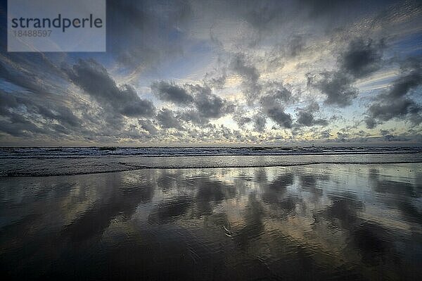 Wolkenhimmel und Spiegelung in der Brandung  Stimmung am Strand nach Sonnenuntergang  Insel Texel  Nordsee  Nordholland  Niederlande  Europa