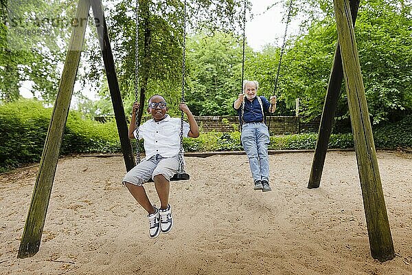 Großeltern auf Zeit. Großvater schaukelt mit seinem Schützling auf einem Spielplatz.  Bonn  Deutschland  Europa