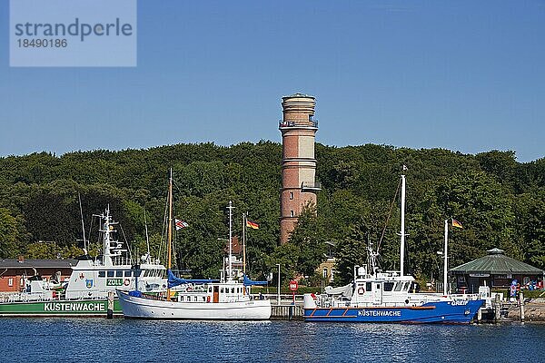 Patrouillenboote der Küstenwache und der alte Leuchtturm im Hafen von Travemünde in der Abenddämmerung  Hansestadt Lübeck  Deutschland  Europa