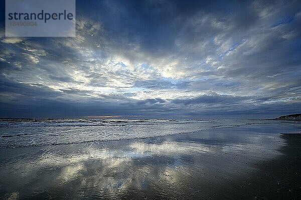Wolkenhimmel und Spiegelung in der Brandung  Stimmung am Strand nach Sonnenuntergang  Insel Texel  Nordsee  Nordholland  Niederlande  Europa