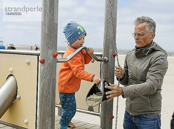 Mann spielt mit einem Kind am Strand.  Borkum  Deutschland  Europa